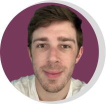 Homem jovem com barba curta, cabelos castanhos, vestindo uma camiseta branca, sorrindo levemente, com fundo roxo